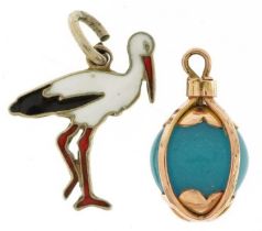Two charms comprising Danish sterling silver and enamel stork from Ribe and an unmarked gold caged
