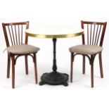 Contemporary circular bistro table with cast iron base and two mahogany chairs with cushions, the