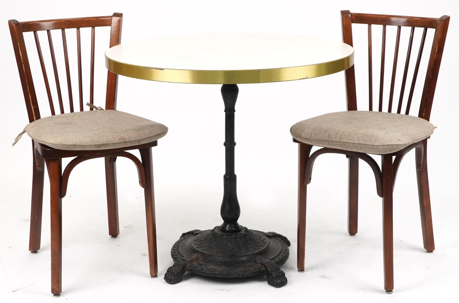 Contemporary circular bistro table with cast iron base and two mahogany chairs with cushions, the