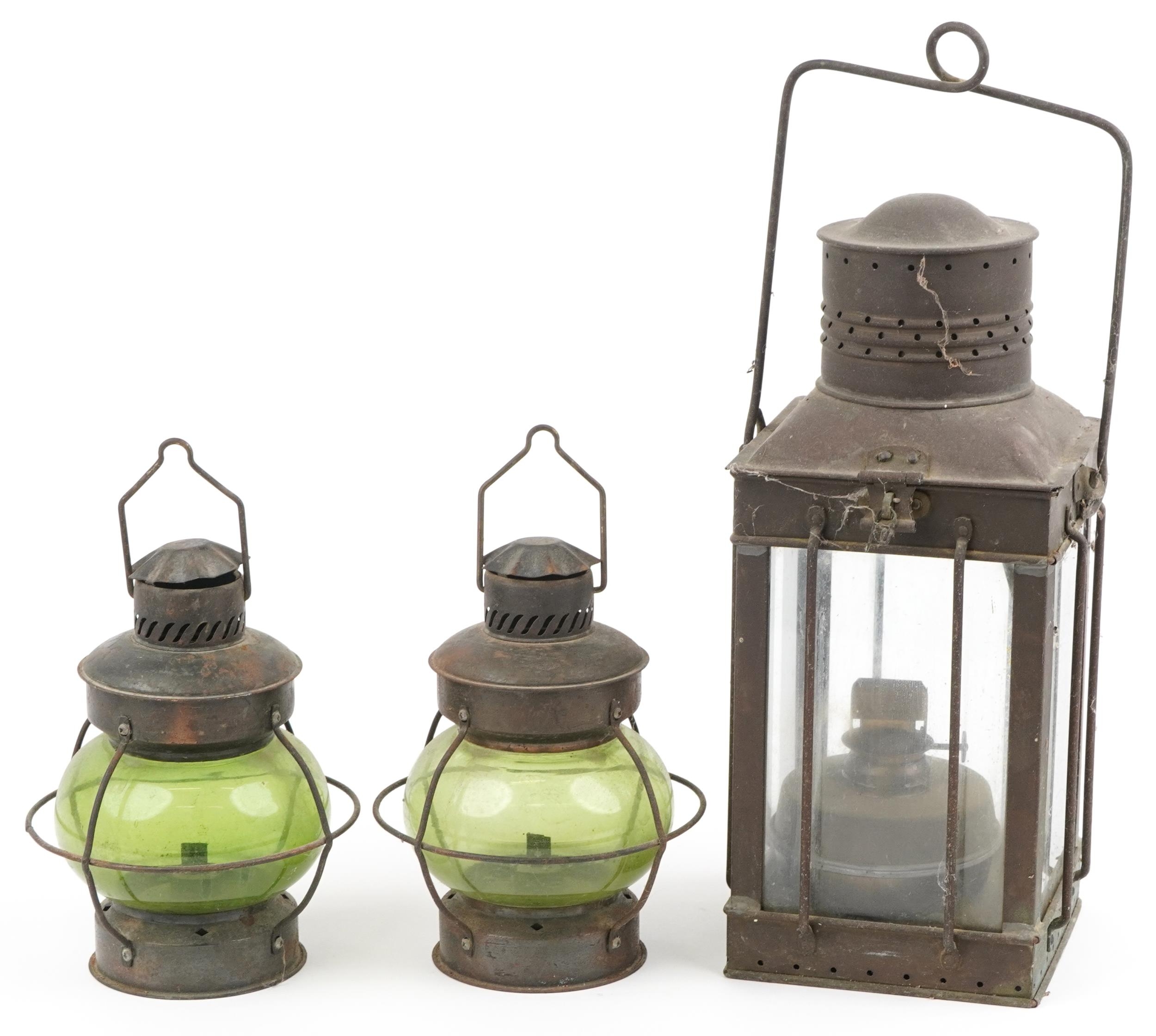 Three shipping interest hanging lanterns including a pair with green glass, the largest 47cm high
