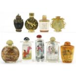 Nine Chinese snuff bottles including a green and russet jade archaic style example, carved bone