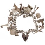 Silver charm bracelet with love heart padlock and a collection of mostly silver charms including