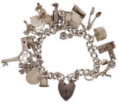 Silver charm bracelet with love heart padlock and a collection of mostly silver charms including