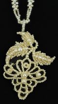 Antique pearl pendant in the form of grapes on a vine on a pearl necklace with a yellow metal barrel