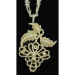 Antique pearl pendant in the form of grapes on a vine on a pearl necklace with a yellow metal barrel