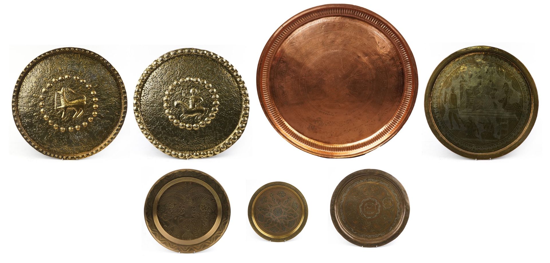 Seven Islamic and Middle Eastern trays including a Cairoware example with silver and copper inlay