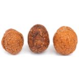 Three Chinese walnuts carved with figures, the largest 4.5cm high