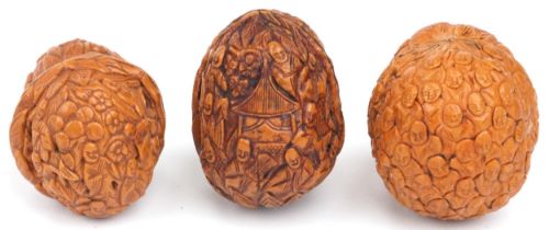 Three Chinese walnuts carved with figures, the largest 4.5cm high