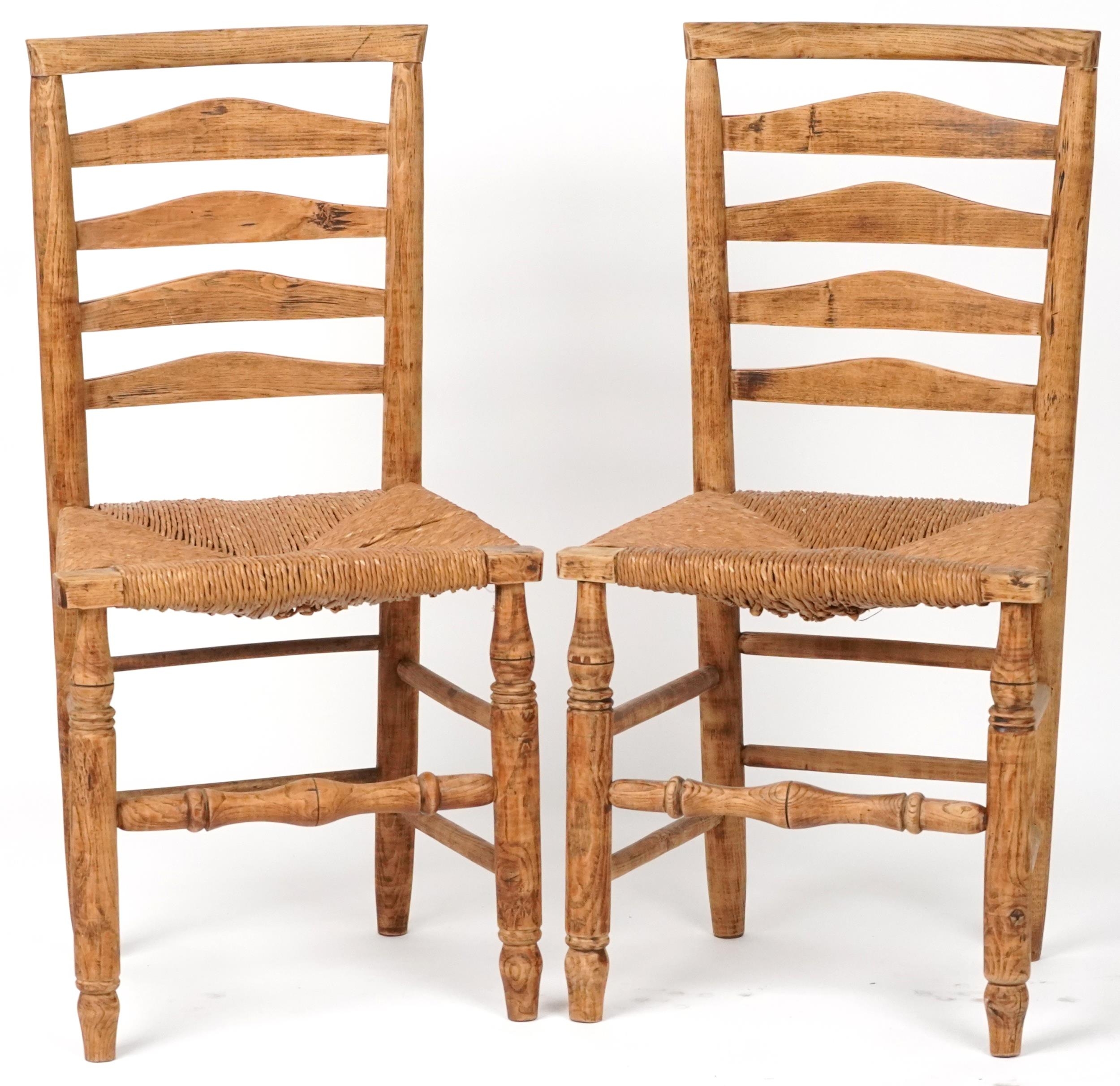 Pair of beech ladderback chairs with cane seats, each 93cm high