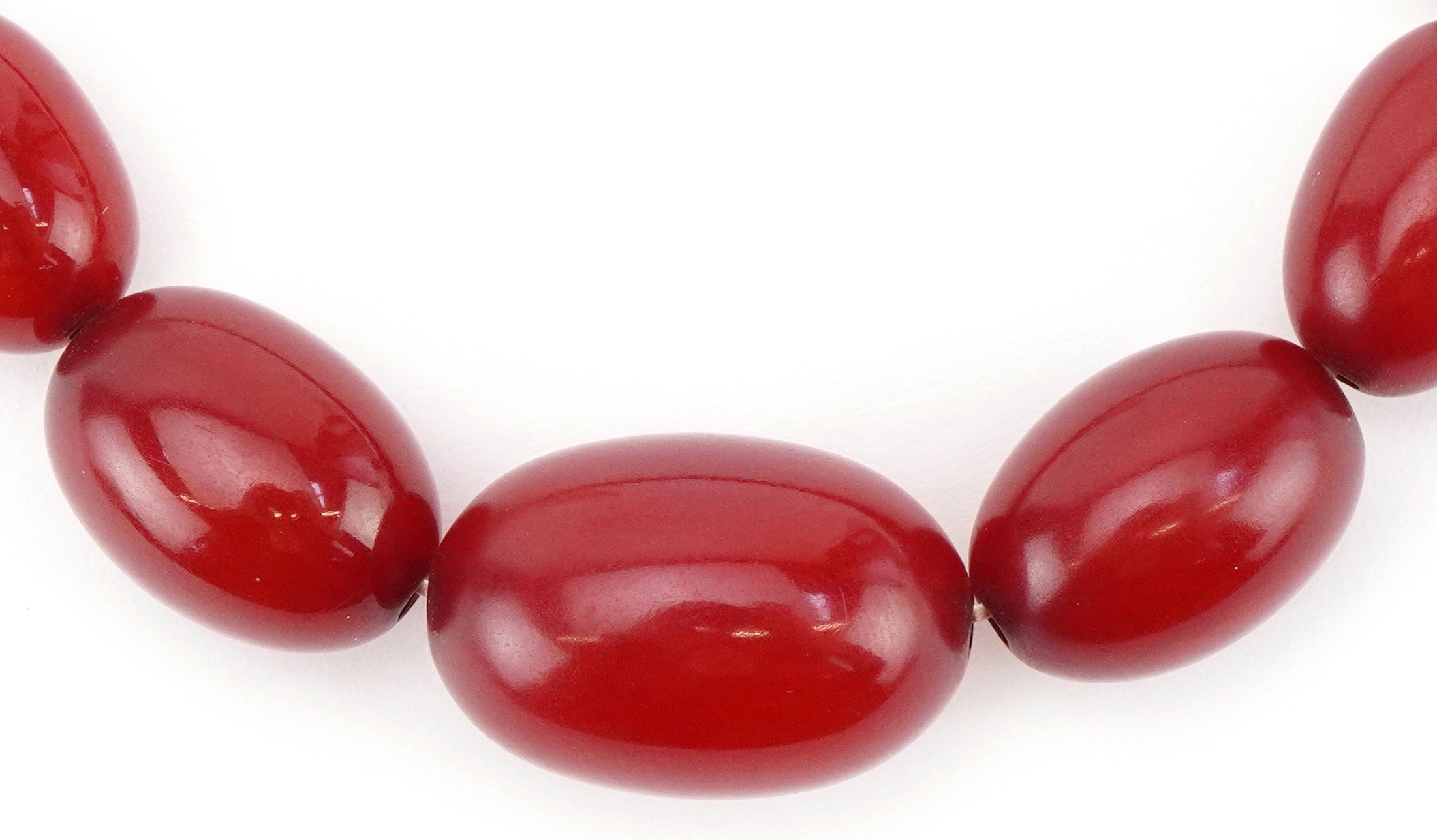 Cherry amber coloured graduated bead necklace, the largest bead approximately 25mm x 17mm in
