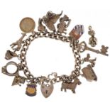 Silver charm bracelet with a collection of mostly silver charms, 57.6g