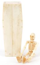 Novelty carved bone articulated model of a human skeleton housed in a sectional bone coffin, 11.