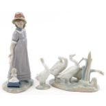 Lladro model of a girl with her doll in a cart together with a model of geese and a single goose,