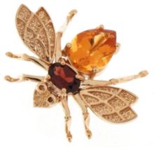 John C Rinker, 10K gold brooch in the form of a fly with garnet and citrine body, 2.6cm wide, 3.5g
