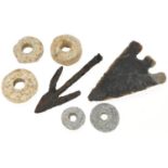 Five lead spindle whorls and two arrow heads, possibly Roman and stone age, the largest 8cm in