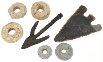 Five lead spindle whorls and two arrow heads, possibly Roman and stone age, the largest 8cm in
