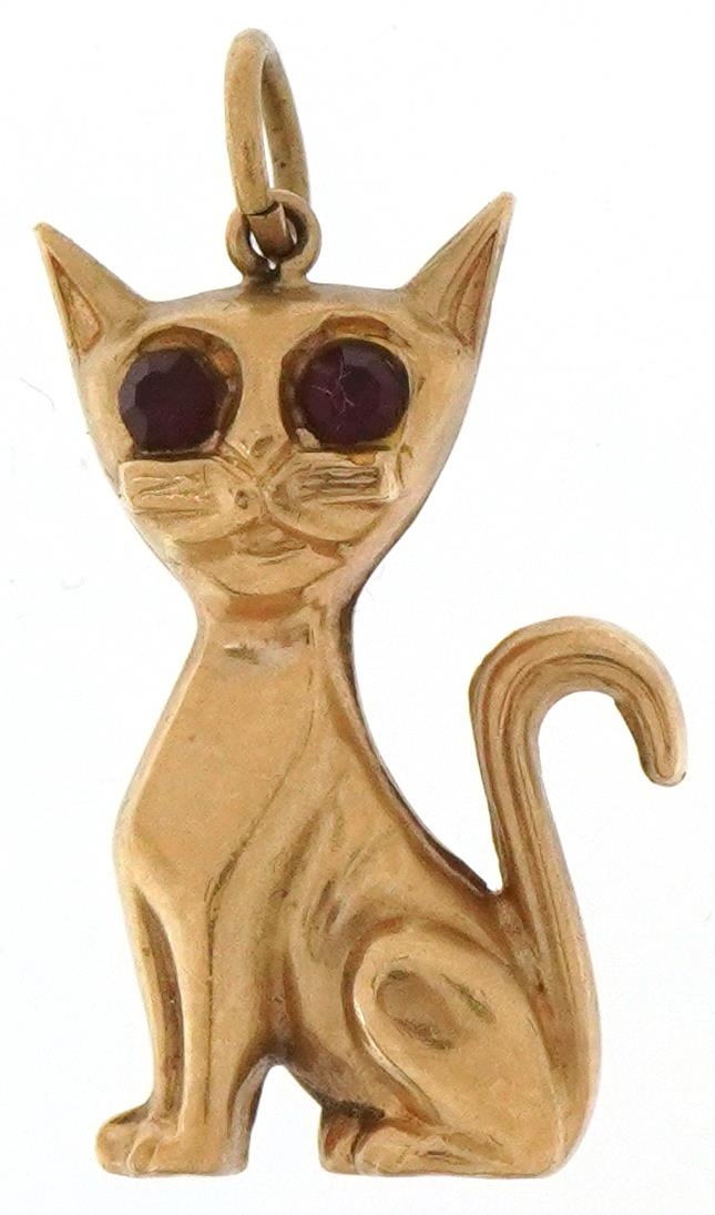 9ct gold charm in the form of a seated cat with red glass eyes, 2.5cm high, 1.3g