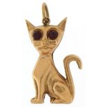 9ct gold charm in the form of a seated cat with red glass eyes, 2.5cm high, 1.3g