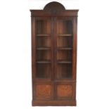Art Nouveau oak glazed bookcase fitted with three adjustable shelves above a cupboard base, 228cm