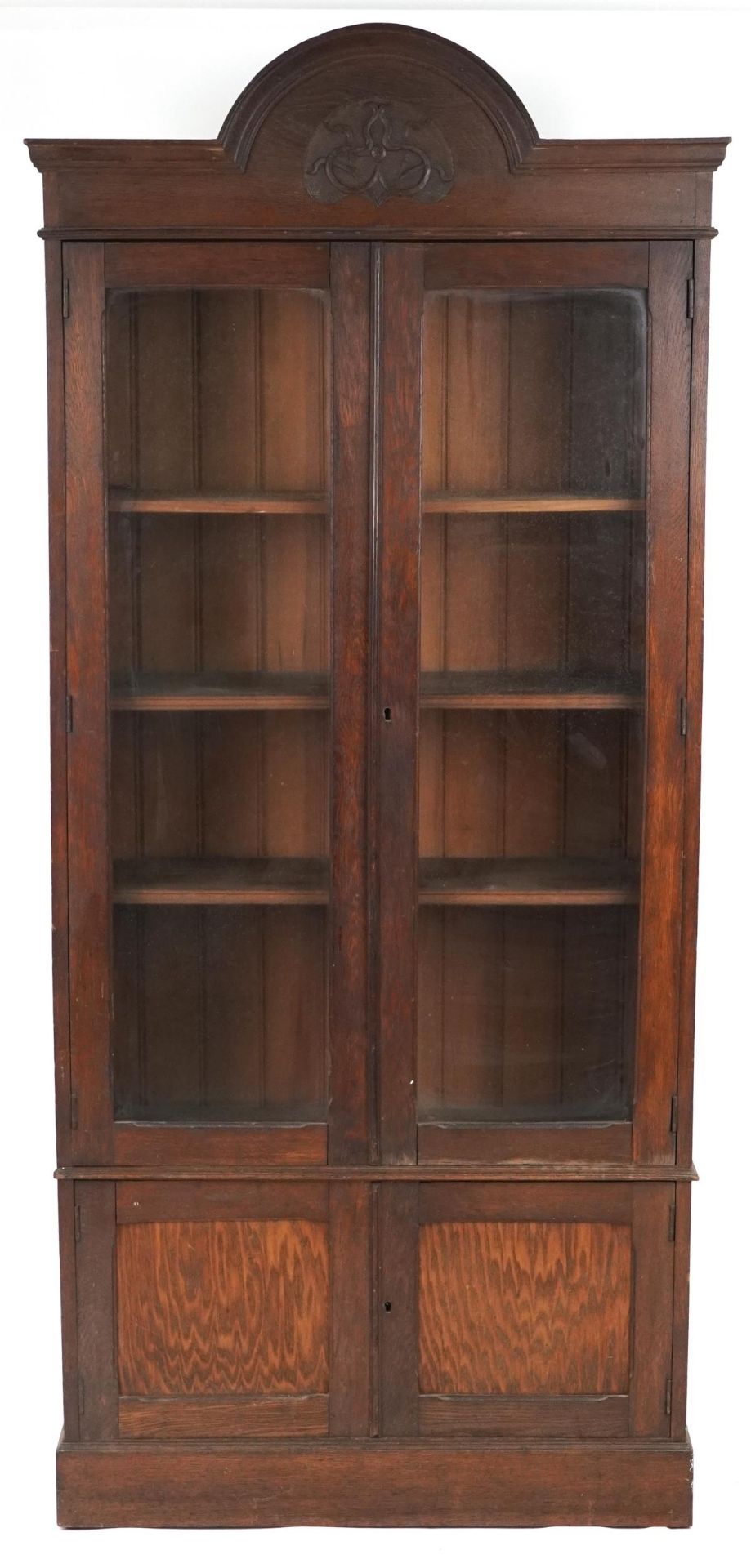 Art Nouveau oak glazed bookcase fitted with three adjustable shelves above a cupboard base, 228cm