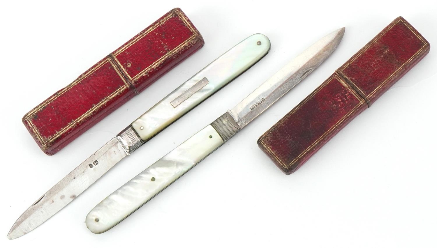 Two Georgian mother of pearl flanked silver folding fruit knives, each housed in a tooled leather