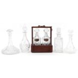 Six glass decanters including a pair housed in a hardwood tantalus with bronze mounts and silver