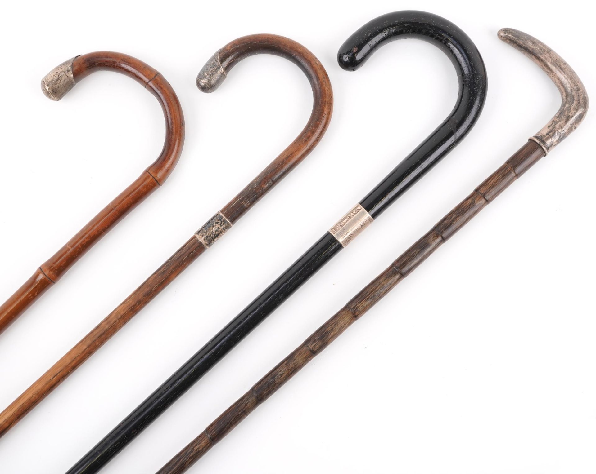 Four silver mounted wooden walking sticks, the largest 90cm in length