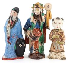 Three Chinese and Japanese figures including a Satsuma example of a young boy, the largest 23.5cm