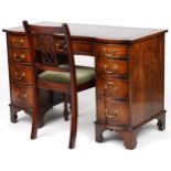 Mahogany serpentine front twin pedestal desk and a mahogany chair, the desk with nine drawers and