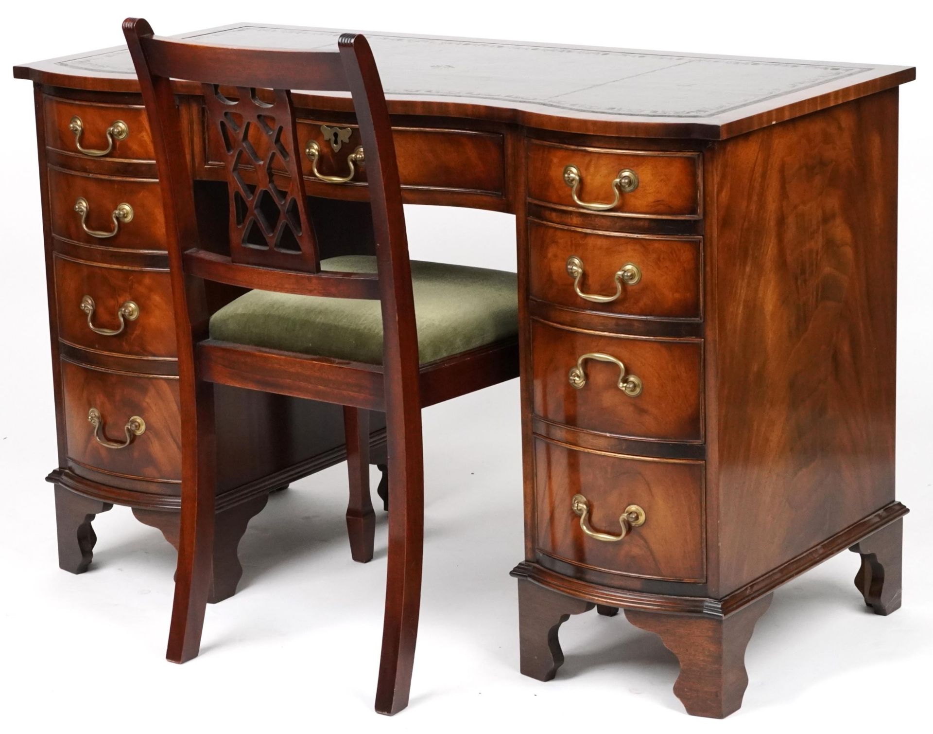 Mahogany serpentine front twin pedestal desk and a mahogany chair, the desk with nine drawers and