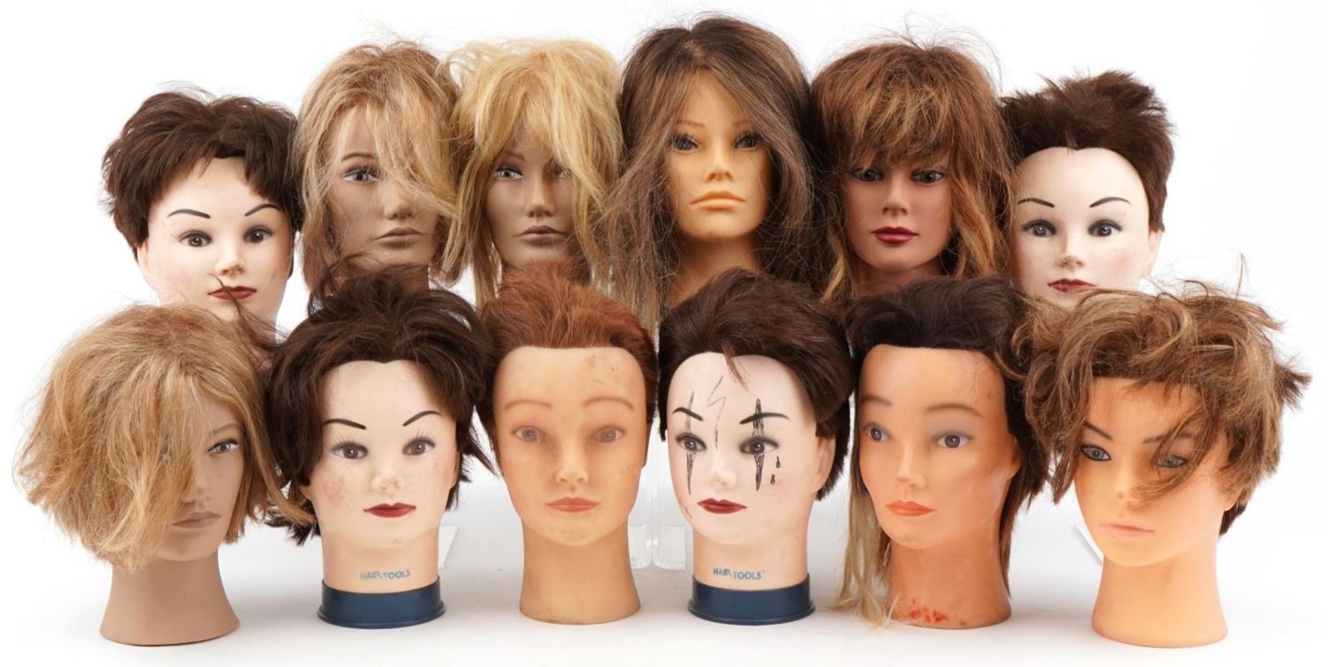 Collection of hairdresser's training mannequin heads including L'Image and hair tools