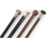 Two ebony silver topped walking sticks and two hardwood walking sticks, three with silver mounts,