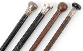 Two ebony silver topped walking sticks and two hardwood walking sticks, three with silver mounts,