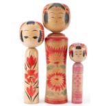 Three Japanese wooden and lacquered Kokeshi dolls, the largest 36cm high