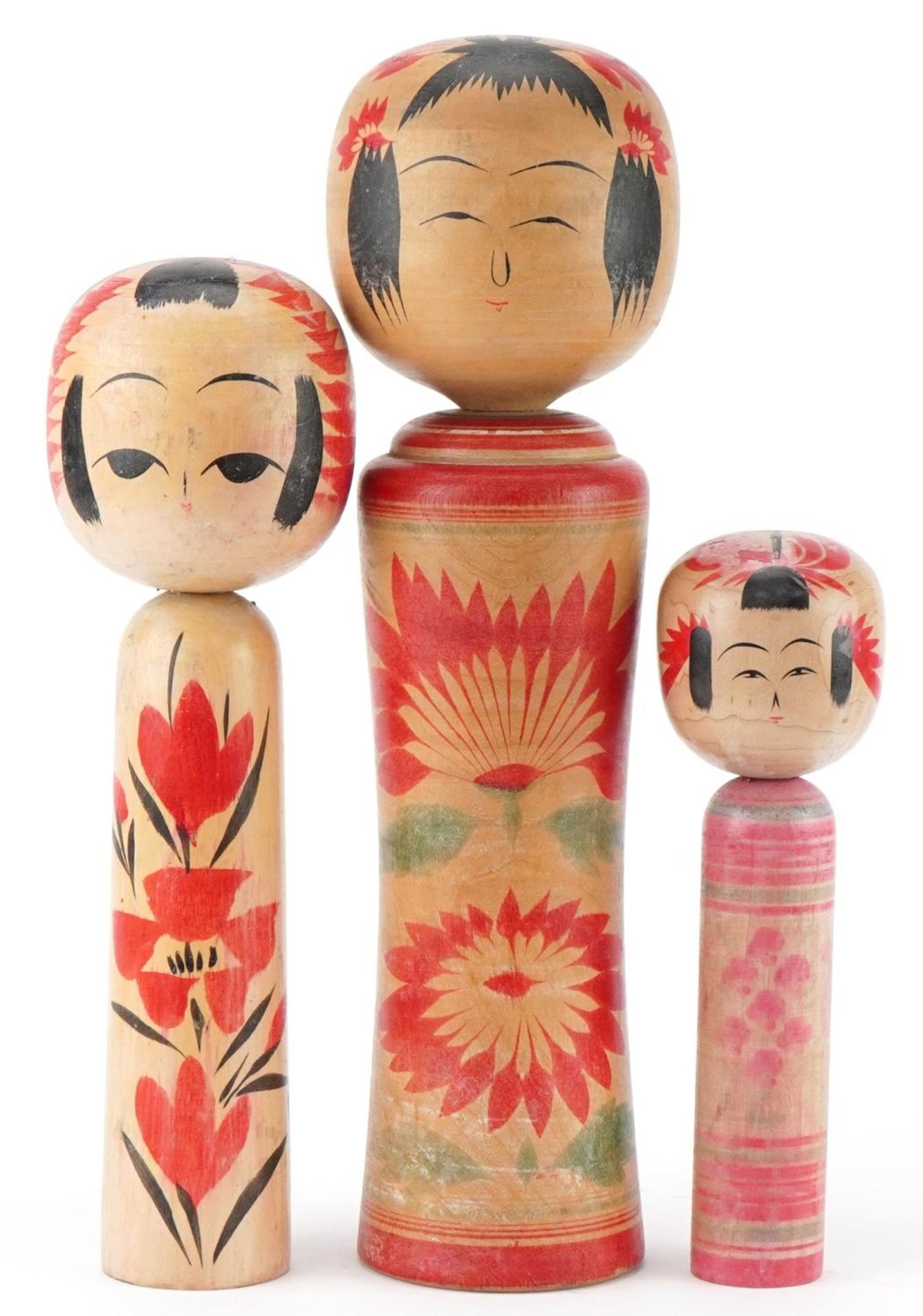 Three Japanese wooden and lacquered Kokeshi dolls, the largest 36cm high