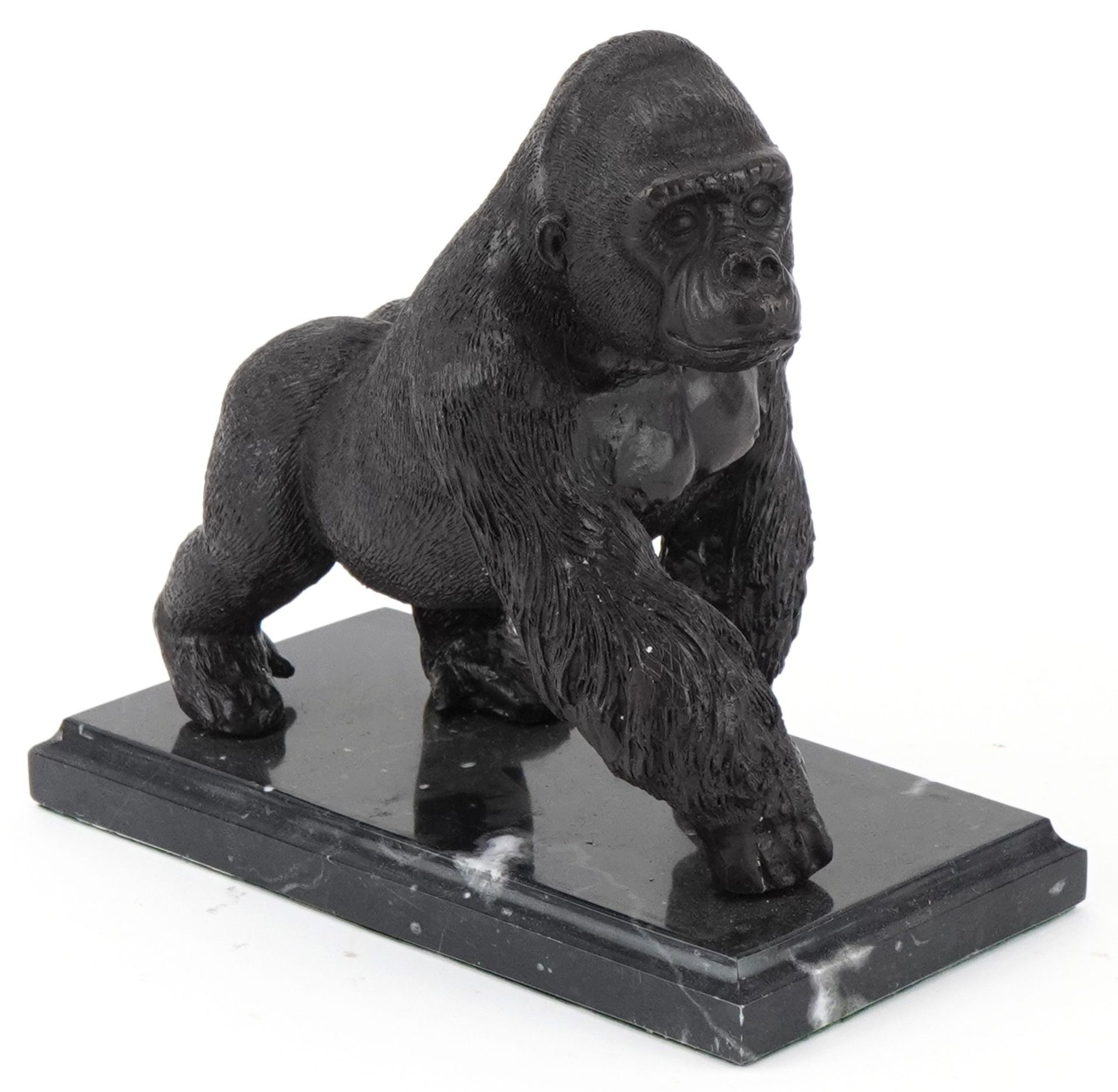 Patinated bronze study of a gorilla raised on a black marble base, 20cm in length