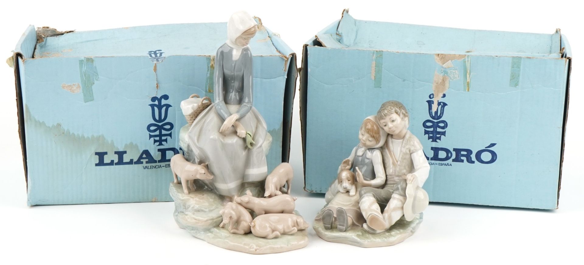Two Lladro figure groups with boxes comprising Figurine Precocious 4856 and girl with piglets