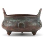 Chinese patinated bronze three footed censer with twin handles, 8cm wide