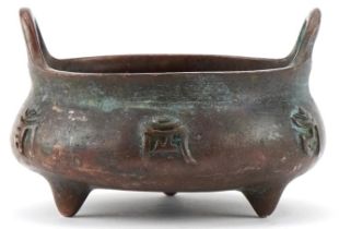Chinese patinated bronze three footed censer with twin handles, 8cm wide