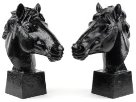 Pair of classical black painted cast iron horseheads on tapering square bases, each 61.5cm high