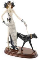 A Santini, Art Deco style statuette of a female with puma wearing a white dress, raised on an oval