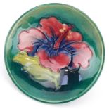 Moorcroft pottery footed dish hand painted and tubelined in the Hibiscus pattern, paper label to the