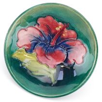 Moorcroft pottery footed dish hand painted and tubelined in the Hibiscus pattern, paper label to the