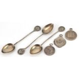 Silver motorcycling interest objects comprising three sports jewels and three teaspoons, the
