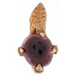 9ct gold charm in the form of dragon claw holding a cabochon garnet, 2.1cm high, 3.4g