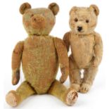 Two golden straw filled teddy bears with jointed limbs and beaded eyes, the largest with bells,