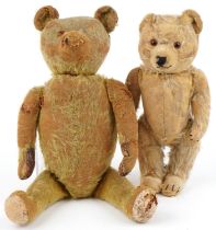 Two golden straw filled teddy bears with jointed limbs and beaded eyes, the largest with bells,