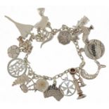 Silver charm bracelet with a collection of mostly silver charms including Concorde, Nefertiti, stick