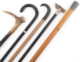 Four wooden walking sticks including one with a hoof design handle, malacca cane and Oriental silver