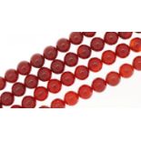 Two carnelian bead necklaces, one with a Chinese white metal clasp, 66cm and 42cm in length, total